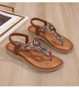 Détail de sandales bohèmes à talons compensés avec perles colorées et design en T