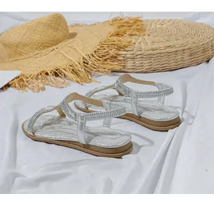 Details von silbernen flachen Sandalen mit Strasssteinen und elastischem Fersenriemen