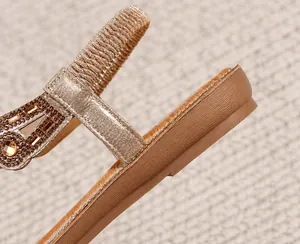 Dettaglio della zeppa da 2,5 cm e degli strass scintillanti sul sandalo color champagne