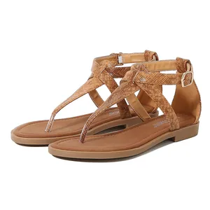 Detail of brown T-strap sandals with snake-skin texture and golden adjustable ankle buckle