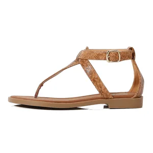Detail view of brown snake print flat T-strap sandals with gold adjustable buckle