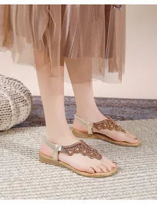 Λεπτομέρεια από boho φλατ σανδάλια σαμπανιζέ με περίτεχνες χάντρες και στρας