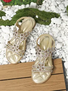 Detail of bohemian flat sandals with hollow design and floral rhinestone patterns