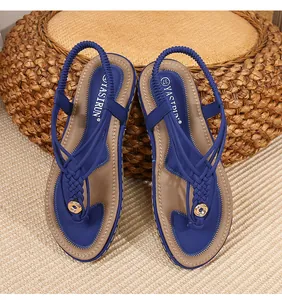 Détail de sandales bohèmes bleues avec brides tressées et ornements en métal doré