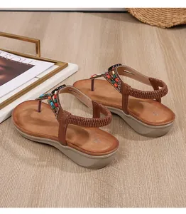 Détail de sandales bohèmes compensées avec perles colorées et strass sur bois
