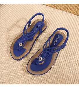 Détail de sandales plates bohèmes avec brides tressées bleu marine et élastique