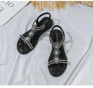 Details von flachen Boho-Sandalen mit grauen Tropfensteinen und glitzernden Strasssteinen