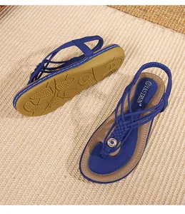 Détail de sandales bohèmes à brides en T avec lanières bleues tressées et semelle antidérapante