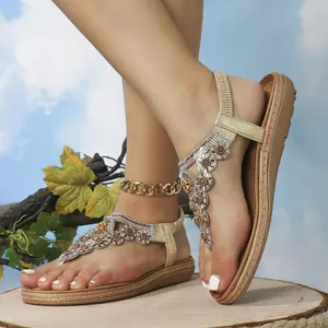Detail von böhmischen Gold-Sandalen mit Blumen-Strasssteinen und passender Fußkette