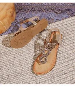 Détail de sandales bohèmes à lanières en T avec strass et motifs floraux en pierres
