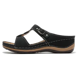 Nahaufnahme schwarzer Strass-Keilsandalen mit T-Riemen und weißer Kontrastnaht-Verarbeitung