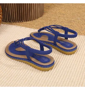 Détail de sandales plates bohèmes bleues avec boucle d'orteil et lanières tressées
