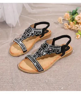 Detail of bohemian flat sandals with sparkling rhinestones and black gemstones decor