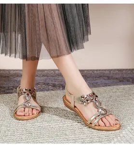 Detail der Bohème-Flachsandalen mit funkelndem Strass-Blumenmuster und elastischem Riemen