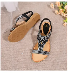 Detail of bohemian black sandals featuring rhinestone T-strap and non-slip wavy sole texture