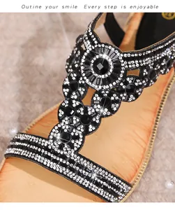 Close-up of bohemian flat sandals featuring intricate black gemstones and silver rhinestones