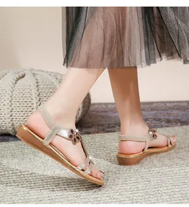Detail von böhmischen Goldsandalen mit floralem Edelsteinbesatz und flacher Glitzersohle