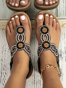 Detail of bohemian wedge sandals with colorful beads and crystal floral pattern decoration