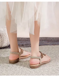 Dettaglio di sandali bassi boho con strass scintillanti e cinturino elastico sul tallone