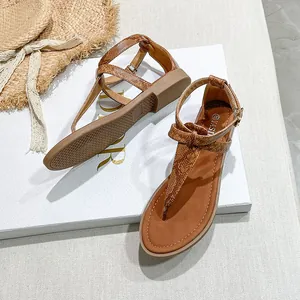 Detailed view of caramel brown toe-post Roman sandals with a textured snake-skin finish