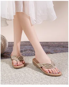 Voetaanzicht van champagne goudkleurige sleehak sandalen met parels en strass steentjes