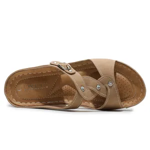 Detailansicht der kamelfarbenen Strass-Sandalen mit Kreuzriemen und weißen Kontrastnähten