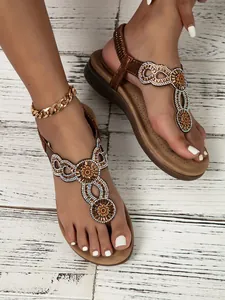 Detail of bohemian flat sandals with colorful rhinestones and elastic heel strap