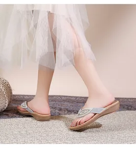 Close-up van bohemien zilveren slippers met strassteentjes en parels op een model