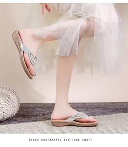 Detailopname van bohemian zilveren teenslippers met strass-steentjes en beige plateauzool
