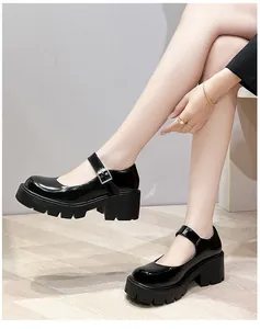 Detailopname van zwarte lakleren Mary Jane platform-schoenen met blokhak en gespen