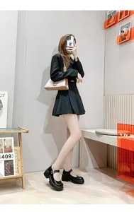 Chique platform Mary Janes gecombineerd met plooirok en zwarte blazer outfit