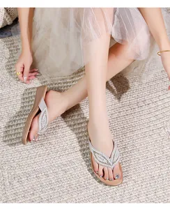 Detail van zilveren boheemse sandalen met elegante V-vormige bandjes met strasstenen