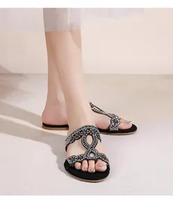 Détail de sandales bohèmes avec strass brillants et motifs de vagues ajourés