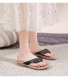 Detail van zwarte teensandalen met blad-strass decoratie gedragen met een tule rok