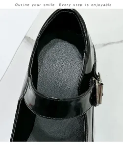 Macro-opname van zwarte lakleren Mary Janes met zilveren gespen en getextureerde binnenzool