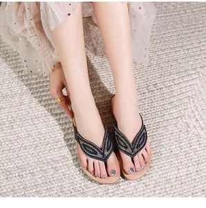 Detail van bohemian platte sandalen met glinsterende strass-steentjes en kralenmotieven