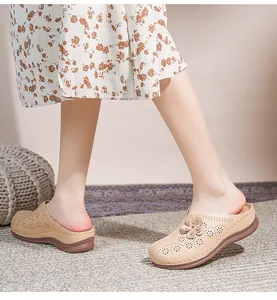 Detail view of beige hollow-out mule shoes featuring floral leather applique and soft rubber sole