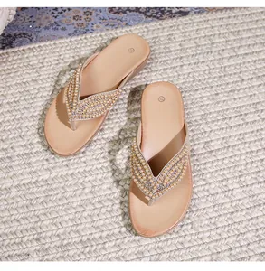 Gedetailleerd bovenaanzicht van beige bohemien slippers met sierparels en strassteentjes