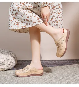 Detail of beige hollow-out mule shoes with floral cutouts and side flower decor