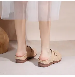 Détail de mule beige ajourée avec semelle compensée et boucle dorée élégante