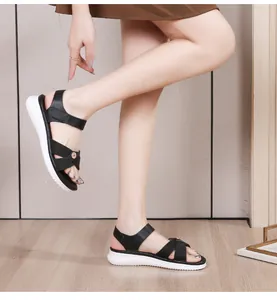 Detail view of black platform sandals with elastic cross straps and white wavy outsole
