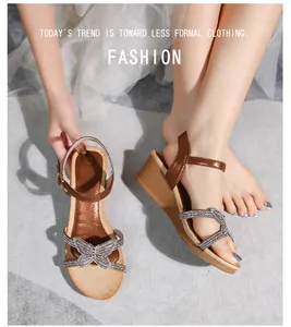 Details einer böhmischen Keilsandalette mit Strass-Schleife und braunem Glanzriemen