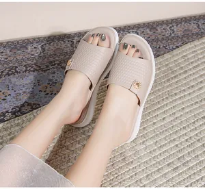 Beigefarbene Bohemian-Sandalen mit geflochtenen Riemen und goldener Sonnenblumenschnalle