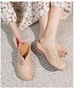 Detail of beige hollow-out mule shoes with floral laser-cut patterns and soft thick soles