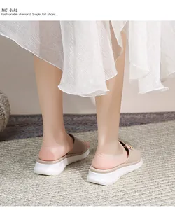 Detail von flachen Bohemian-Sandalen mit elastischen Riemen und goldener Schnalle