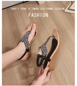 Close-up of black T-strap wedge sandals with sparkly rhinestone floral patterns