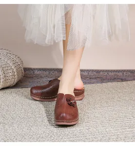 Detail of retro dark brown hollow-out leather mules with handmade floral applique and thick sole