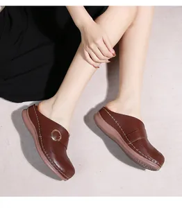 Détails de mules à plateforme en cuir marron foncé avec perforations et boucle métallique