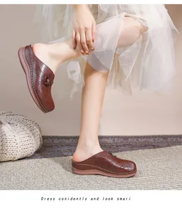 Detail of brown leather clogs with laser-cut floral patterns and 3D flower accents