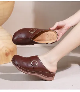 Vue détaillée de mules marron foncé avec découpes laser et boucle en métal argenté brillant